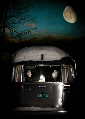 couple with a pug in an airstream camper